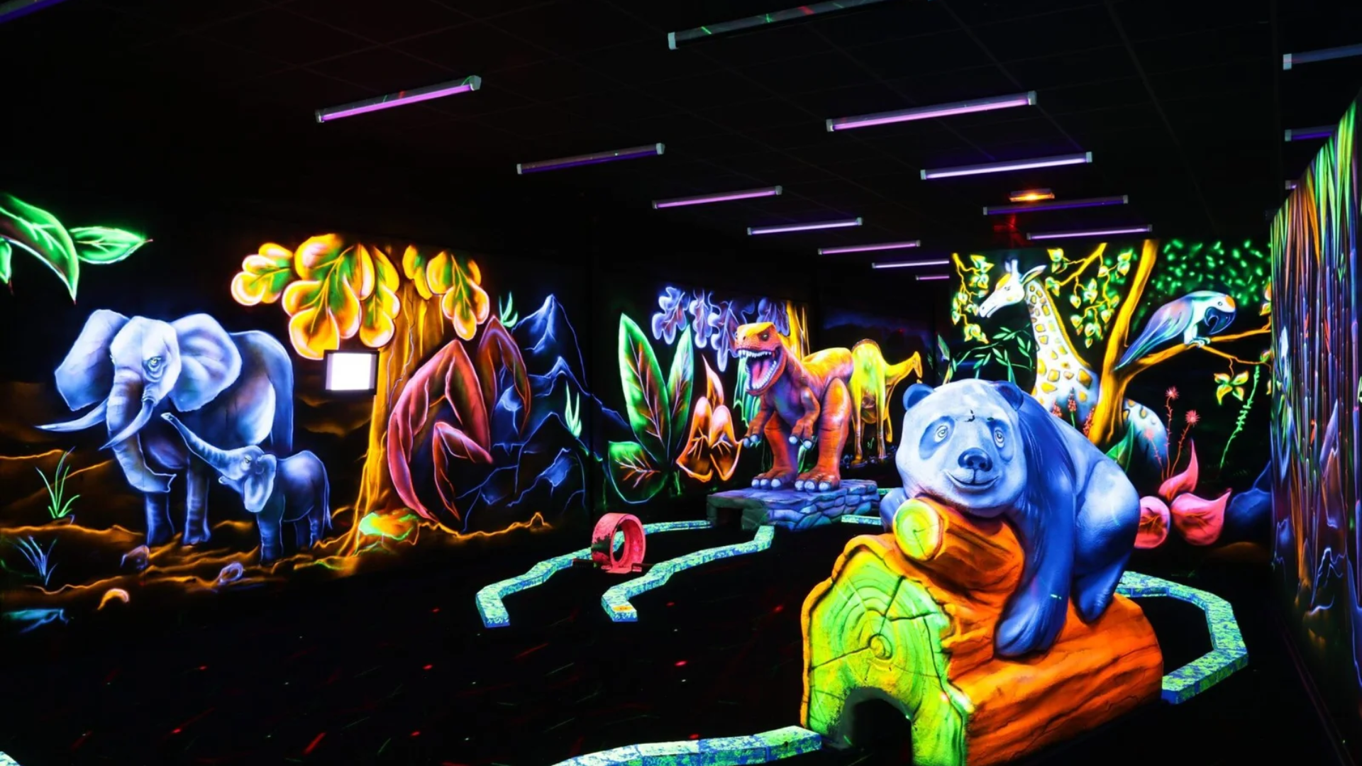 Décors peints à la peinture fluorescente révélés sous lumière noire au mini golf de Montauban
