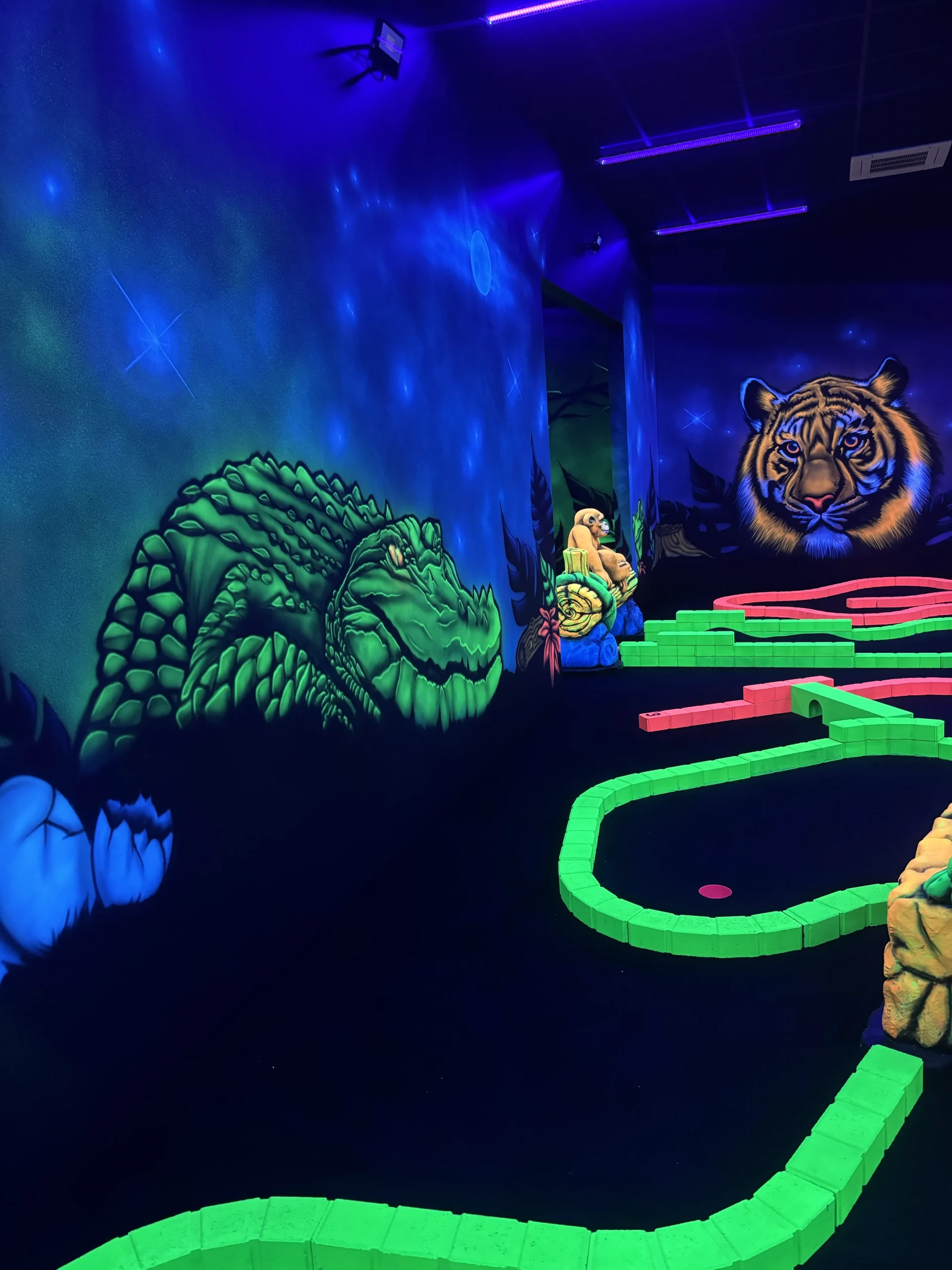 Crocodile et tigre peints sur la fresque murale du mini golf fluo de Montauban