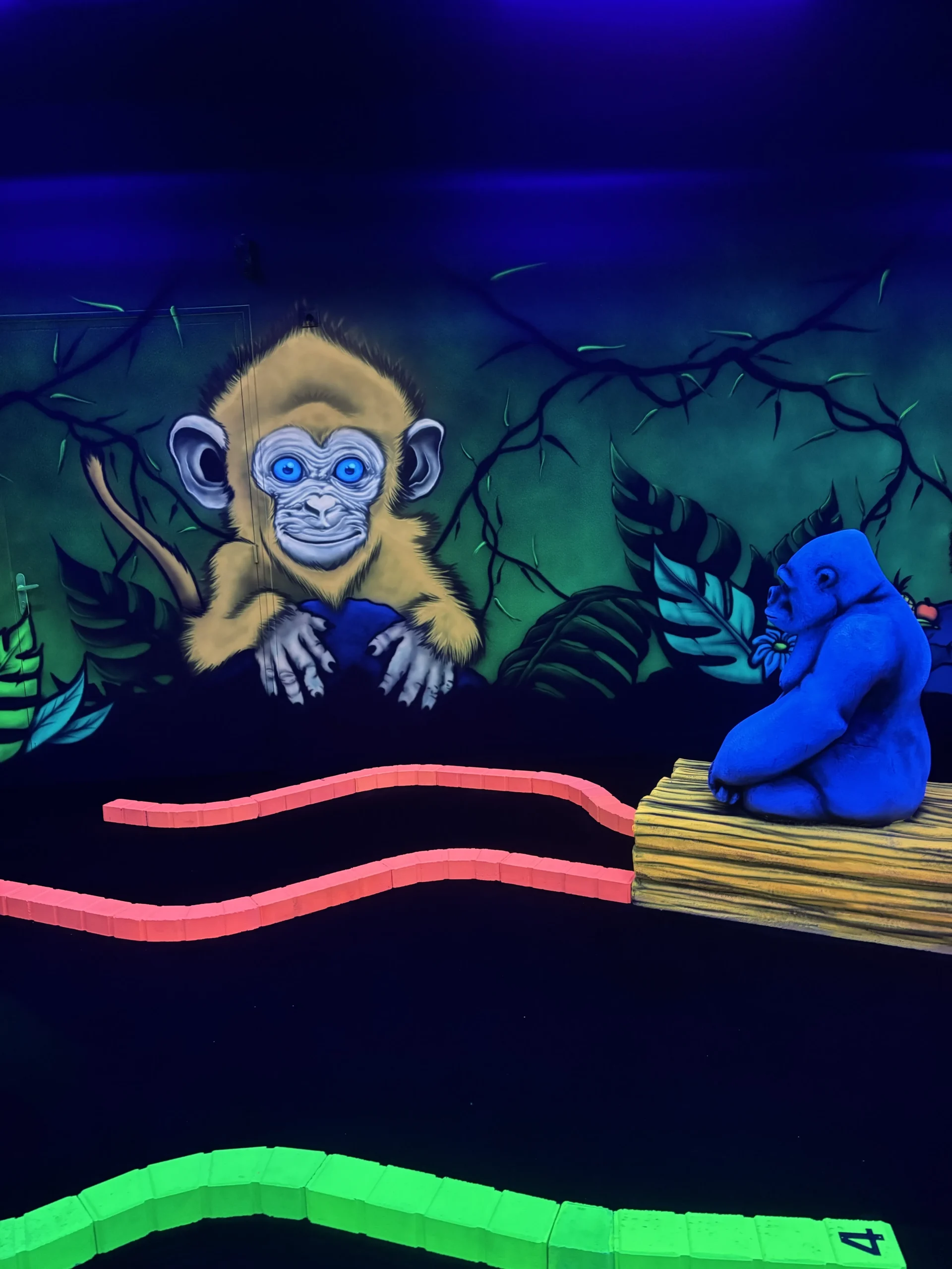 Singe et gorille peints sur le décor de jungle du parcours de mini-golf